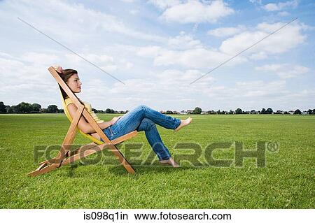 Picture - Young woman in deckchair. Fotosearch