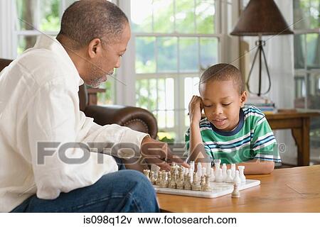 A grandfather and grandson playing chess View Large Photo Image Stock Photo - A grandfather and grandson playing chess. Fotosearch