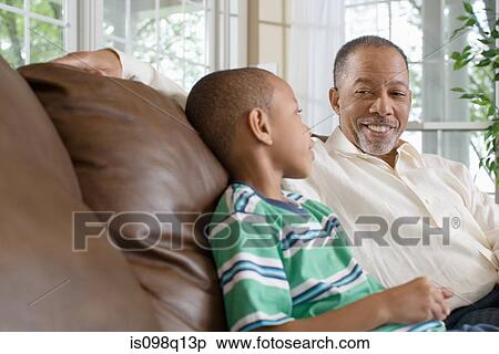 A grandfather and grandson sitting on a sofa View Large Photo Image Stock Photography - A grandfather and grandson sitting on a sofa. Fotosearch