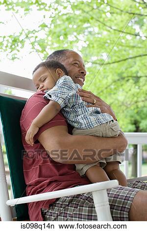A grandfather holding his sleeping grandson View Large Photo Image Picture - A grandfather holding his sleeping grandson. Fotosearch