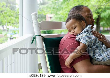 A grandfather holding his sleeping grandson View Large Photo Image Stock Photo - A grandfather holding his sleeping grandson. Fotosearch