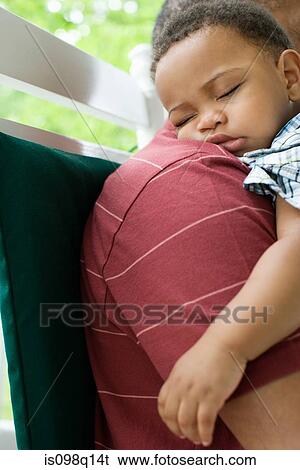 A grandfather holding his sleeping grandson View Large Photo Image Stock Photograph - A grandfather holding his sleeping grandson. Fotosearch