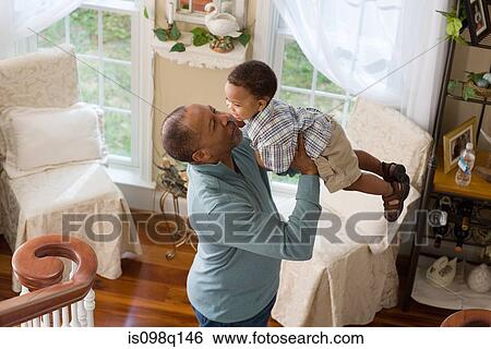 A grandfather lifting his grandson in the air View Large Photo Image Stock Photograph - A grandfather lifting his grandson in the air. Fotosearch