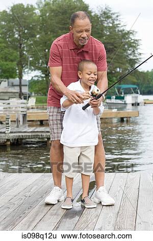 A grandfather teaching his grandson to fish View Large Photo Image Stock Photograph - A grandfather teaching his grandson to fish. Fotosearch