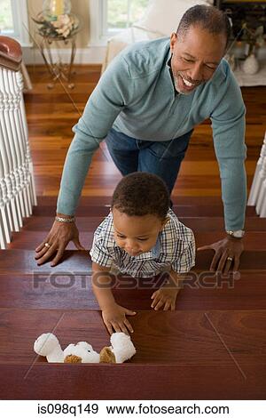 A grandfather watching his grandson climb the stairs View Large Photo Image Stock Photo - A grandfather watching his grandson climb the stairs. Fotosearch
