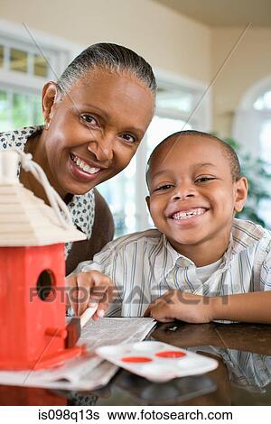 A grandmother and grandson painting a birdhouse View Large Photo Image Stock Photograph - A grandmother and grandson painting a birdhouse. Fotosearch