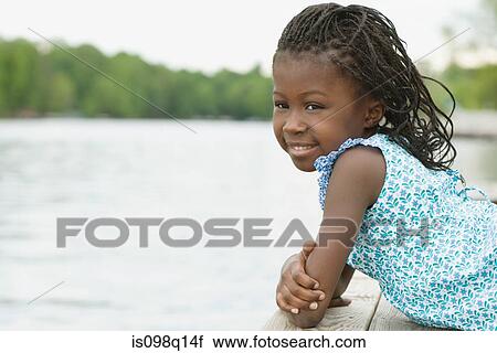 Stock Image - Girl lying on a jetty. Fotosearch