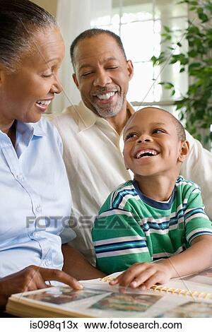 Grandparents and their grandson looking at a photo album View Large Photo Image Stock Photo - Grandparents and their grandson looking at a photo album. Fotosearch
