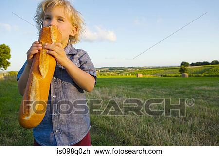 A boy eating a baguette View Large Photo Image Stock Image - A boy eating a baguette. Fotosearch