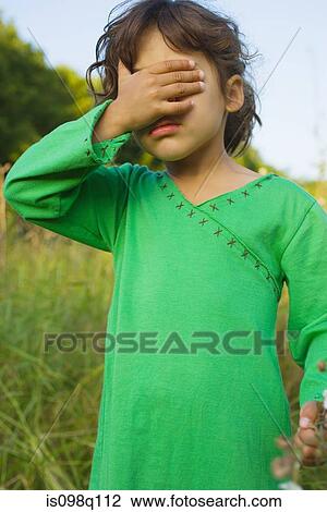 Stock Image - A girl covering her eyes. Fotosearch