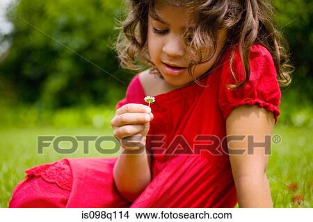 Picture - A girl holding a daisy. Fotosearch