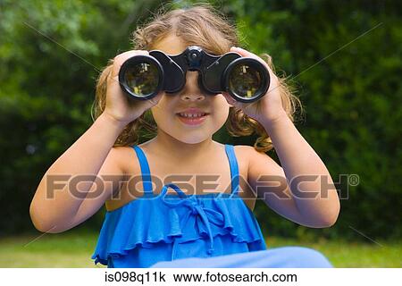 Stock Image - A girl looking through binoculars. Fotosearch