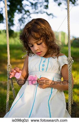 A girl picking petals off a flower View Large Photo Image Stock Image - A girl picking petals off a flower. Fotosearch