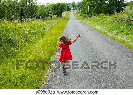 A girl skipping down a country road View Large Photo Image Stock Image - A girl skipping down a country road. Fotosearch