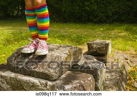 A girl standing on rocks View Large Photo Image Stock Photo - A girl standing on rocks. Fotosearch