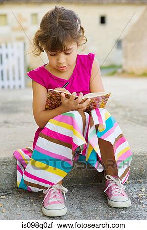 A girl writing in a book View Large Photo Image Stock Image - A girl writing in a book. Fotosearch