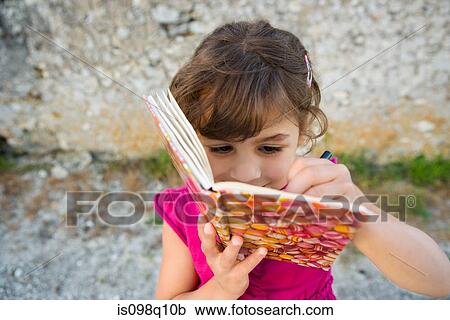 A girl writing in a book View Large Photo Image Stock Image - A girl writing in a book. Fotosearch