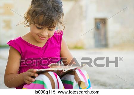 A girl writing in a book View Large Photo Image Stock Photography - A girl writing in a book. Fotosearch
