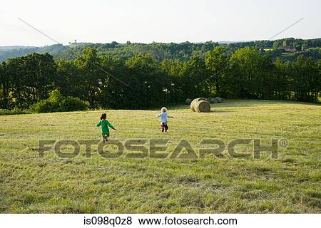 Boy and girl running down a field View Large Photo Image Stock Photo - Boy and girl running down a field . Fotosearch