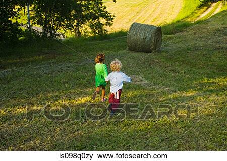 Boy and girl running down a field View Large Photo Image Stock Photo - Boy and girl running down a field . Fotosearch