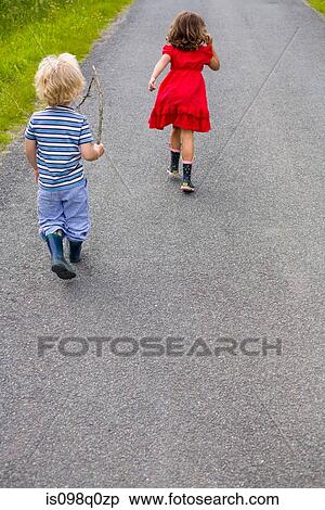 Boy and girl running down a road View Large Photo Image Stock Photography - Boy and girl running down a road . Fotosearch