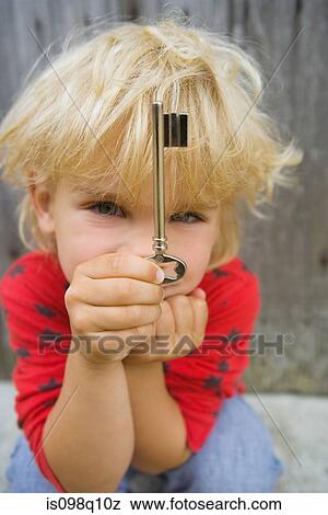Portrait of a boy holding a key View Large Photo Image Stock Photo - Portrait of a boy holding a key. Fotosearch