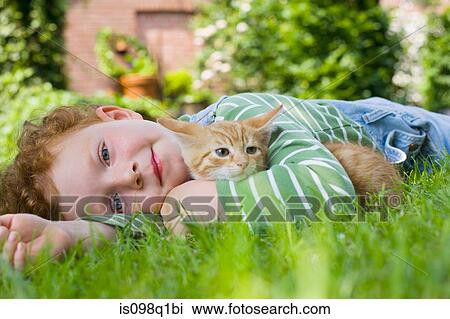 Stock Image - A boy holding a kitten. Fotosearch
