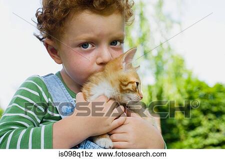 Stock Photo - A boy holding a kitten. Fotosearch