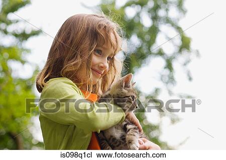 Stock Image - A girl holding a kitten. Fotosearch