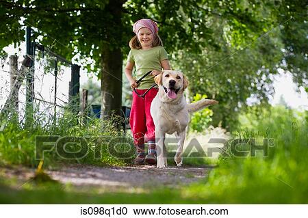 Stock Image - A girl walking a dog. Fotosearch