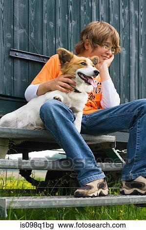 Stock Image - Boy sitting on a step with his dog. Fotosearch