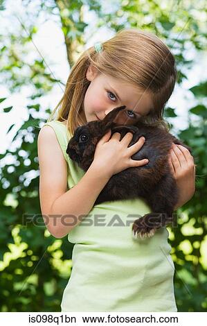 Picture - Portrait of a girl holding a rabbit. Fotosearch