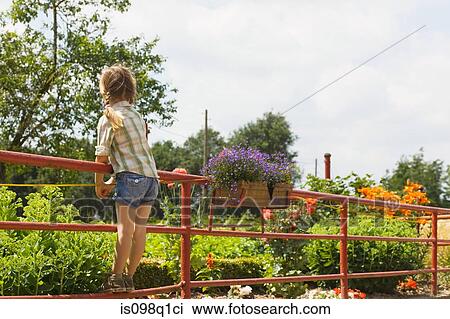 Rear view of a girl standing on a fence View Large Photo Image Stock Image - Rear view of a girl standing on a fence. Fotosearch