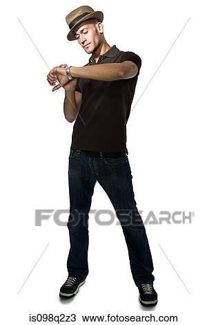 Young man checking his watch View Large Photo Image Stock Image - Young man checking his watch. Fotosearch