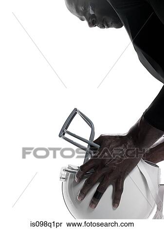 Stock Photography - American football player holding a helmet. Fotosearch