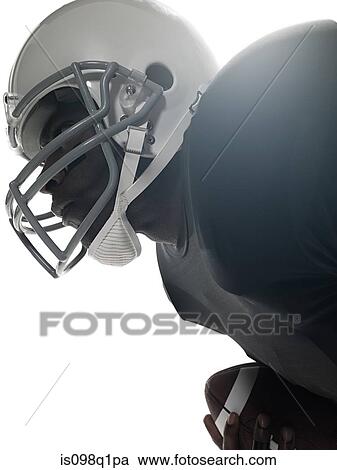 Stock Image - An american football player holding a football. Fotosearch