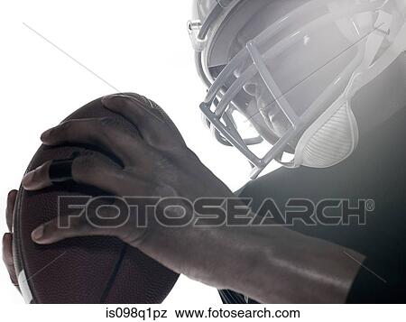 An american football player holding a football View Large Photo Image Stock Photo - An american football player holding a football. Fotosearch