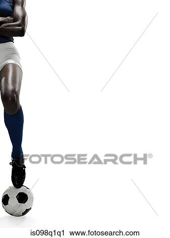 Stock Image - Portrait of a woman with her foot on a ball. Fotosearch