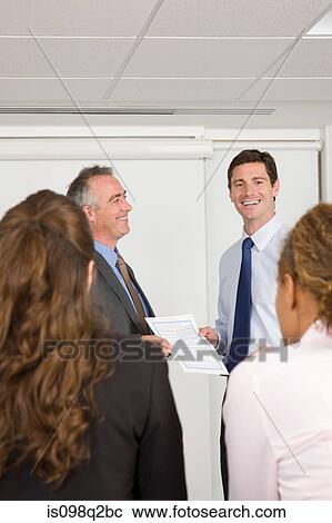 Stock Image - A lecturer handing a certificate to a student. Fotosearch