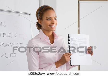 Stock Photo - A lecturer holding a textbook. Fotosearch