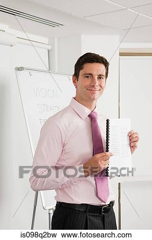 Stock Photo - A lecturer holding a textbook. Fotosearch