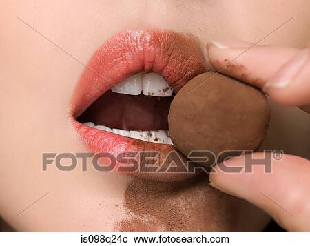 Woman eating chocolate truffle View Large Photo Image Stock Image - Woman eating chocolate truffle. Fotosearch