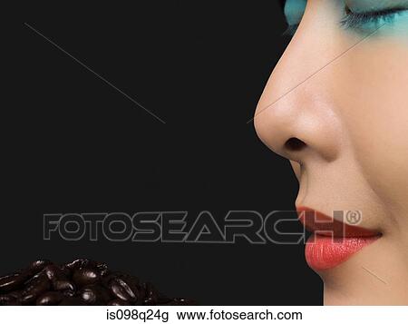 Stock Image - Woman smelling coffee beans. Fotosearch