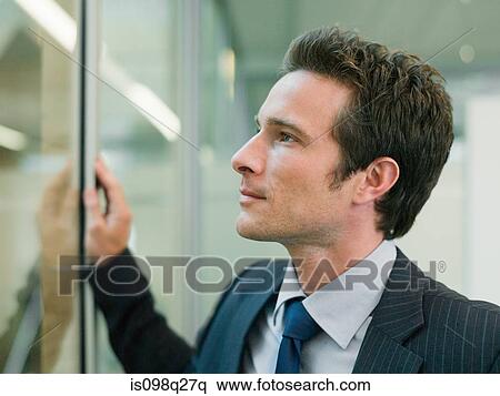 Businessman looking through window View Large Photo Image Stock Photography - Businessman looking through window. Fotosearch