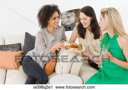 Stock Image - A woman offering friends canapes. Fotosearch