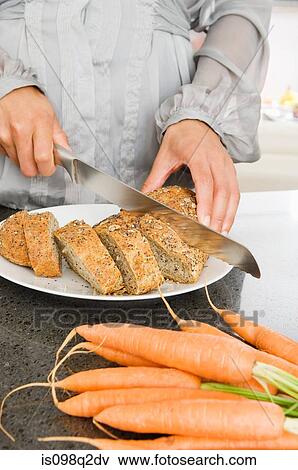 A woman slicing bread View Large Photo Image Stock Photo - A woman slicing bread. Fotosearch