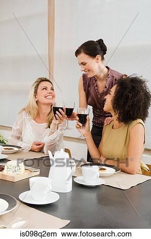 Friends having red wine at a dinner party View Large Photo Image Picture - Friends having red wine at a dinner party. Fotosearch