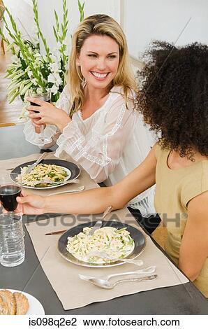 Stock Image - Friends talking at a dinner party. Fotosearch