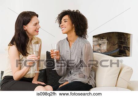 Stock Image - Two women having champagne. Fotosearch