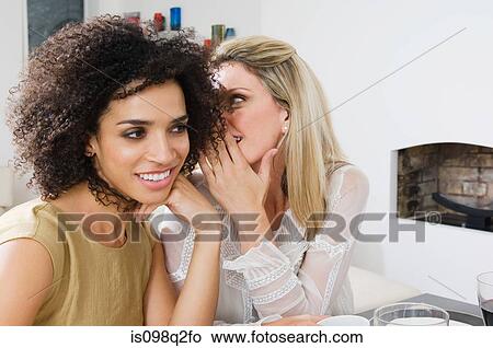 Two women whispering View Large Photo Image Picture - Two women whispering. Fotosearch